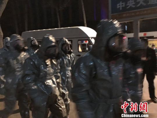 十几名身着防护服的人员头戴面具进入事发地。　胡健 摄